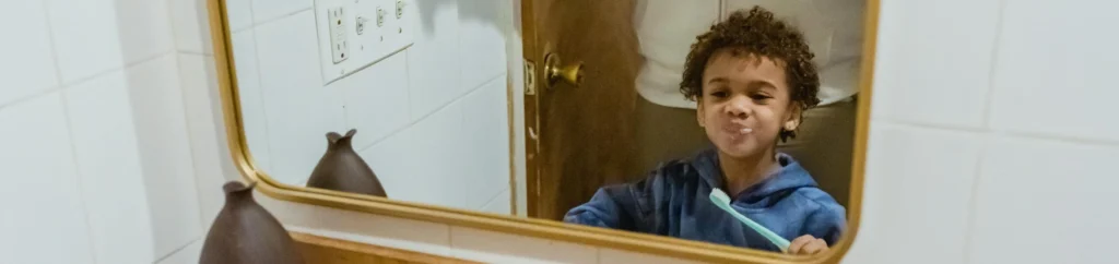 Blij en gemotiveerd kind dat aan het tandenpoetsen is